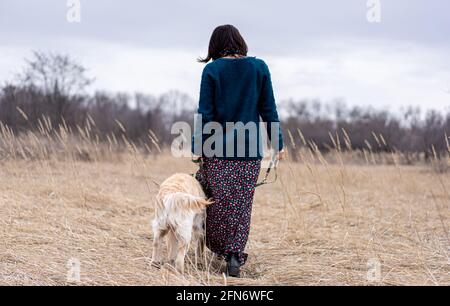 Rückansicht einer Frau, die an der Leine in der Natur läuft Stockfoto