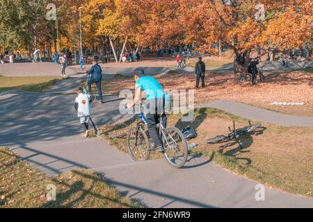 Kazan, Russland - 03. Oktober 2020: Kinder und Jugendliche fahren im öffentlichen Park der Stadt im Herbst Roller und Fahrräder Stockfoto