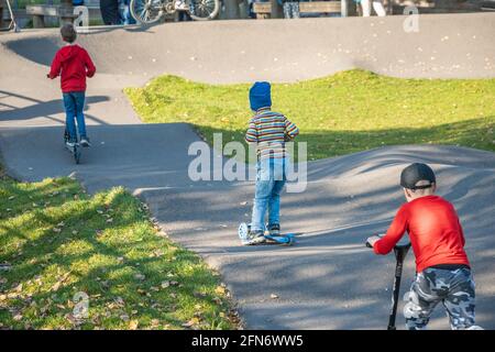 Kazan, Russland - 03. Oktober 2020: An einem sonnigen Herbsttag fahren Kinder im öffentlichen Park der Stadt mit einem Roller Stockfoto