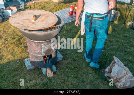 Kazan, Russland - 03. Oktober 2020: Bedeckt mit einem Holzdeckel, einem großen Kessel mit Pilaf auf einem Holzofen aus einem Eisenfass. Pilaf ist vorbereitet Stockfoto