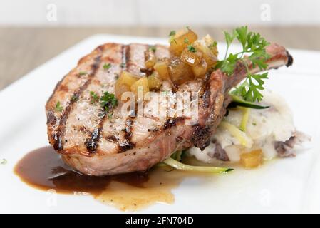 Gegrilltes Schweinekotelett, serviert mit Kartoffelpüree und Pasta, um den herzhaften Appetit zu schwelgen. Stockfoto