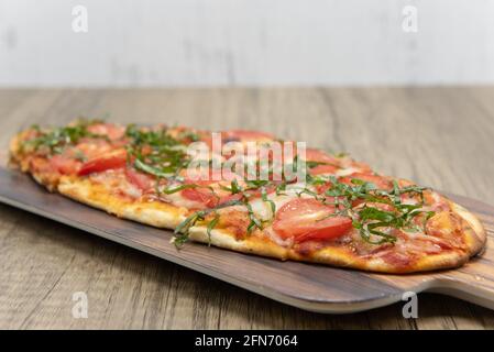 Margarita Fladenbrot Pizza mit Scheiben von Tomaten, Käse auf köstlichen gebackenen Fladenbrot Kruste gekrönt. Stockfoto