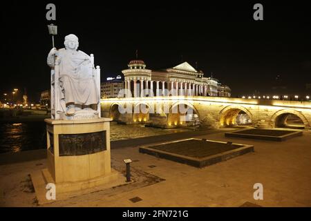 Byzantinische Justinian-Statue und Steinbrücke, hinter dem Archäologiemuseum in der Nacht in Skopje, Mazedonien. Stockfoto