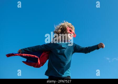 Superhelden-Kind im roten Superhelden-Mantel. Superhelden-Konzept. Stockfoto