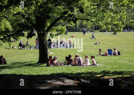 New York, USA. Mai 2021. Die Menschen genießen sich im Central Park in New York, USA, 14. Mai 2021. Die US Centers for Disease Control and Prevention (CDC) werden den vollständig geimpften Amerikanern im Innen- und Außenbereich, auch in Menschenmengen, keine Masken mehr empfehlen, so ihre am Donnerstag angekündigten neuen Leitlinien. Quelle: Wang Ying/Xinhua/Alamy Live News Stockfoto