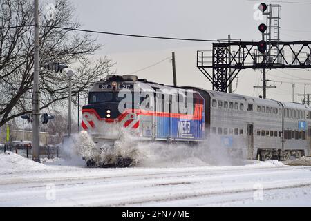 Franklin Park, Illinois, USA. Ein Metra-Pendlerzug schiebt kurz vor der Ankunft am Bahnhof Franklin Park durch den Schnee. Stockfoto