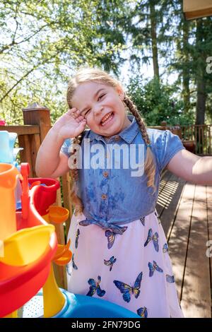 Lynwood, Washington, USA. Vier Jahre altes Mädchen, das Spaß mit ihrem Wasserspielzeug hat. (MR) Stockfoto