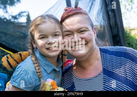 Lynwood, Washington, USA. Das vierjährige Mädchen und ihre Mutter umarmen sich und sind anhänglich. (MR) Stockfoto