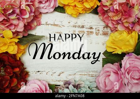 Happy Monday Text und Blumen Bunte Grenze Rahmen auf Holzhintergrund Stockfoto