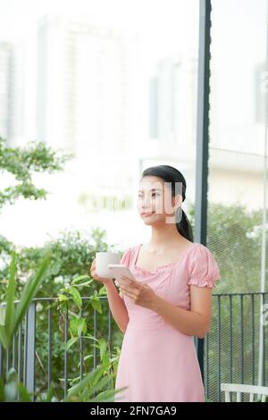 Schöne beiläufige asiatische Frau Urlauber im Freien stehen und tippen auf ihr Handy. Stockfoto