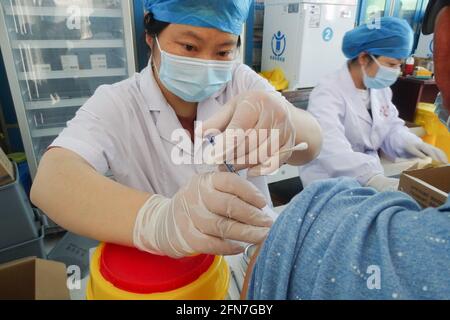 Fuyang, China. Mai 2021. Ein Gesundheitsmitarbeiter verabreicht den Covid-19-Impfstoff an einen Landbewohner an einer Impfstelle für COVID-19 in der Provinz Anhui. Kredit: SOPA Images Limited/Alamy Live Nachrichten Stockfoto