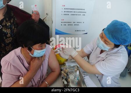 Fuyang, China. Mai 2021. Ein Gesundheitsmitarbeiter verabreicht den Covid-19-Impfstoff an einen Landbewohner an einer Impfstelle für COVID-19 in der Provinz Anhui. Kredit: SOPA Images Limited/Alamy Live Nachrichten Stockfoto