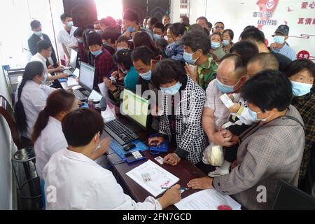 Fuyang, China. Mai 2021. Die Mitarbeiter überprüfen vor dem Impfprozess die persönlichen Informationen von Landbewohnern an einer COVID-19-Impfstelle in der Provinz Anhui. Kredit: SOPA Images Limited/Alamy Live Nachrichten Stockfoto