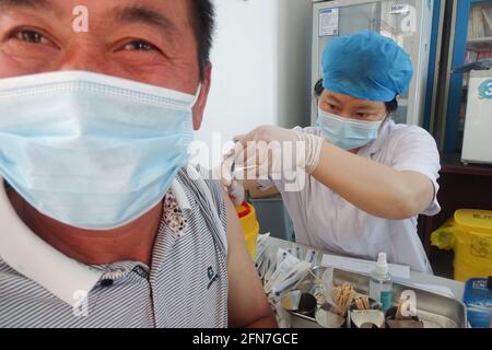 Fuyang, China. Mai 2021. Ein Gesundheitsmitarbeiter verabreicht den Covid-19-Impfstoff an einen Landbewohner an einer Impfstelle für COVID-19 in der Provinz Anhui. Kredit: SOPA Images Limited/Alamy Live Nachrichten Stockfoto