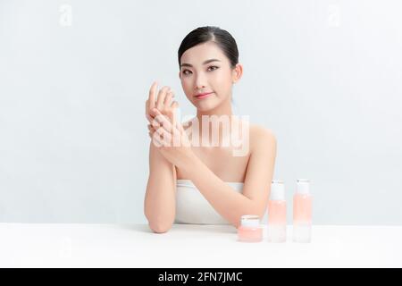 Fröhliche weibliche Vloggerin zeigt Kosmetikprodukte und gibt Ratschläge für ihren Beauty-Blog. Stockfoto