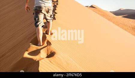 Einsamer Mann zu Fuß auf Sand Crest an der Düne 45 im Sossusvlei Wüste - Wanderlust Konzept mit Wanderer Kerl in der Namibischen berühmten Place - Abenteuer Reise Reisen Stockfoto