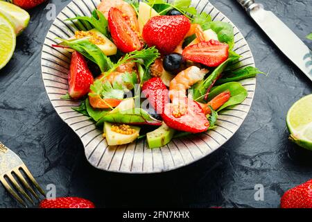 Diätsalat mit Garnelen, Erdbeeren und Avocado.Salat in stilvollem Metall Platte Stockfoto
