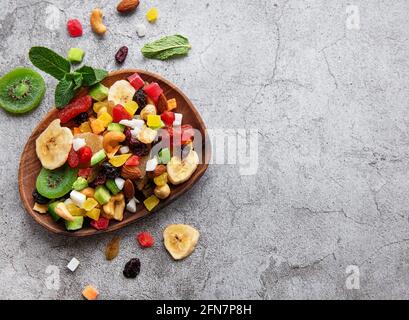 Schüssel mit verschiedenen getrockneten Früchten und Nüssen auf einem grauen Konkreter Hintergrund Stockfoto