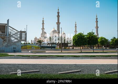 Scheich-Zayed-Moschee in Abu Dhabi, Vereinigte Arabische Emirate an einem sonnigen Tag auf der anderen Straßenseite. Die große Moschee ist die drittgrößte Moschee der Welt Stockfoto