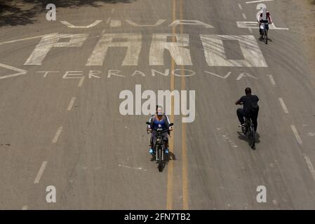 Jamundi, Kolumbien. Mai 2021. Eine Gruppe von Motorradfahrern überquert ein Graffiti, das auf den Nationalstreik auf der Panamericana-Autobahn anspielt. In den letzten zwei Wochen hat Kolumbien zahlreiche Proteste erlebt. Zunächst hatten die Menschen gegen eine umstrittene Steuerreform demonstriert, die seitdem zurückgezogen wurde. Die meisten Demonstranten haben jetzt neue Ziele. Quelle: Christian Escobar/dpa/Alamy Live News Stockfoto
