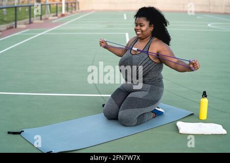 Kurvige Afro-Frau macht Workout-Übungen - Young African Weibliche mit Spaß Training im Freien - Sportliche Menschen Lifestyle-Konzept Stockfoto