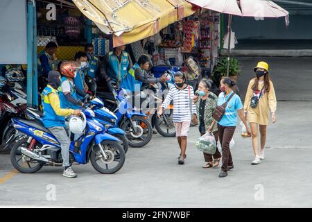 SAMUT PRAKAN, THAILAND, JULI 20 2020, EINE Frau läuft mit Moto-Taxis um den Bahnhof Stockfoto