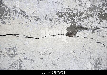 Leere alte verputzte Wandstruktur. Lackierte problematische Wandoberfläche. Verfallene Gebäudefassade mit beschädigtem Putz. Riss. Leer für Designer. Stockfoto