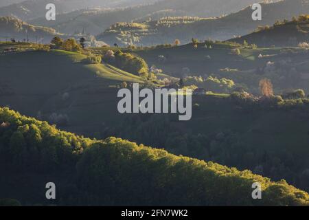 Ländliche Berglandschaft mit abgelegenen rumänischen Dorf bergauf in den Tälern der Karpaten, im Frühling Stockfoto