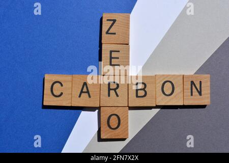 Zero, Carbon, Wörter in Holzalphabetbuchstaben in Kreuzworträtsel-Form isoliert auf blauem und grauem Hintergrund Stockfoto