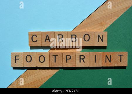 CO2-Fußabdruck, Wörter in Holzbuchstaben isoliert auf buntem Hintergrund Stockfoto