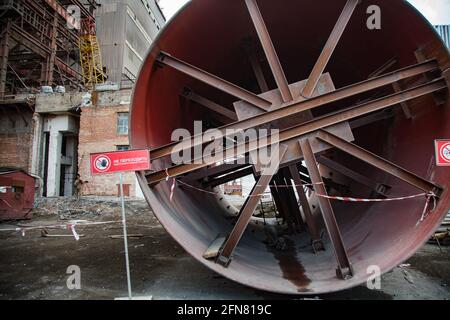 Temirtau, Kasachstan: Abriss eines alten, veralteten sowjetischen Zementwerks. Rotes Verbotsschild und Tisch „No Trespassing“. Rundes Metallfilterteil. Stockfoto