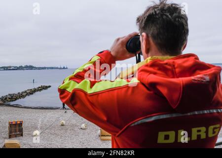 15. Mai 2021, Schleswig-Holstein, Eckernförde: DLRG-Mitarbeiter Björn Fischer schaut durch das Fernglas. Die ersten Stationen der Deutschen Rettungsgesellschaft (DLRG) an der Nord- und Ostsee werden derzeit eröffnet. Foto: Frank Molter/dpa Stockfoto