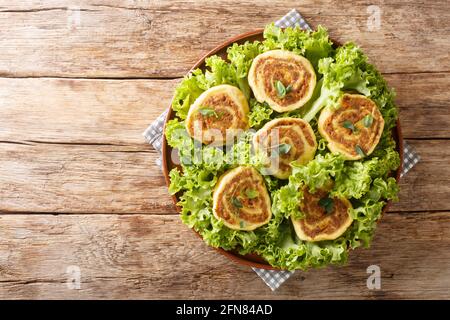 Essen Fleischschnacka Französisches elsässisches Gericht aus gekochter Fleischfüllung, in einem frischen Ei gerollt, in Nahaufnahme auf einem Teller auf dem Tisch gerollt. Horizontal oben Stockfoto