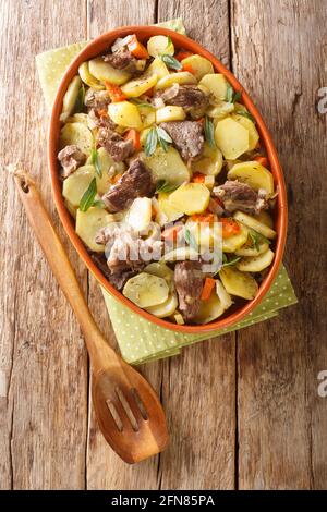Baeckeoffe Französischer elsässischer Eintopf aus drei Fleischsorten, Kartoffeln, Zwiebeln und Karotten in einem Topf auf dem Tisch. Vertikale Draufsicht von oben Stockfoto