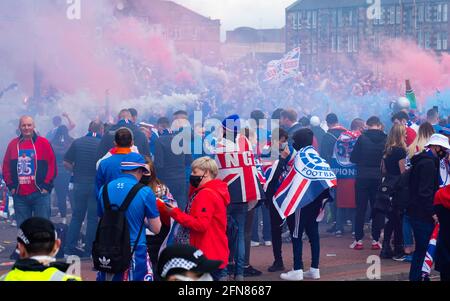 Glasgow, Schottland, Großbritannien. 15 Mai 2021. Hunderte von Fans und Fans des Rangers-Fußballvereins kommen im Ibrox Park in Glasgow zusammen, um den Sieg der schottischen Premiership-Meisterschaft zu feiern. Rauchbomben und Feuerwerk werden von Fans, die von der Polizei streng kontrolliert werden, weg von den Eingängen des Stadions losgelassen.Iain Masterton/Alamy Live News Stockfoto