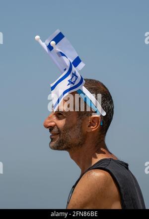 Tel Aviv, Israel - 15. April 2021: Ein Mann, der am 73. Unabhängigkeitstag Israels die israelische Nationalflagge auf dem Kopf trägt. Stockfoto