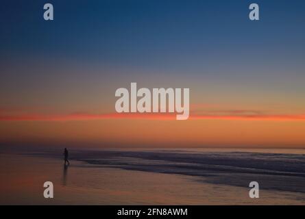 Sonnenuntergangs-Meereslandschaft mit einer Mann-Silhouette an der Küste von Imperial Beach in San Diego, Kalifornien, USA. Stockfoto