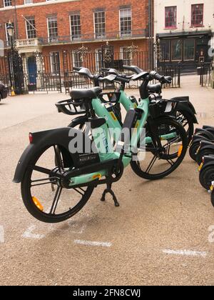 Eine Bucht mit mehrstufigen E-Scootern und E-Bikes neben den ratsbüros im Zentrum von York, North Yorkshire. Stockfoto