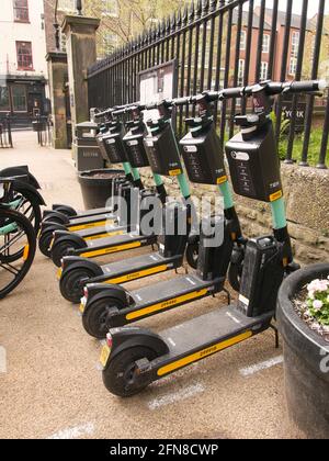 Eine Bucht mit mehrstufigen E-Scootern und E-Bikes neben den ratsbüros im Zentrum von York, North Yorkshire. Stockfoto