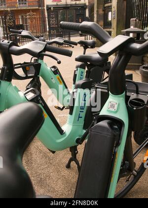 Eine Bucht mit mehrstufigen E-Scootern und E-Bikes neben den ratsbüros im Zentrum von York, North Yorkshire. Stockfoto