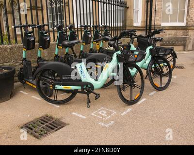 Eine Bucht mit mehrstufigen E-Scootern und E-Bikes neben den ratsbüros im Zentrum von York, North Yorkshire. Stockfoto