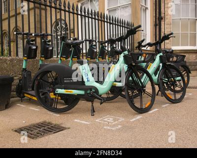 Eine Bucht mit mehrstufigen E-Scootern und E-Bikes neben den ratsbüros im Zentrum von York, North Yorkshire. Stockfoto