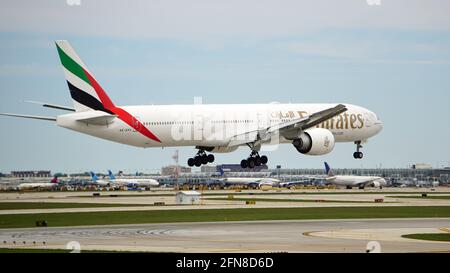 Emirates Boeing 777-300ER landet an einem bewölkten Frühlingstag auf dem Chicago O'Hare International Airport. Der Flug begann in Dubai. Stockfoto