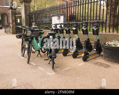 Eine Bucht mit mehrstufigen E-Scootern und E-Bikes neben den ratsbüros im Zentrum von York, North Yorkshire. Stockfoto