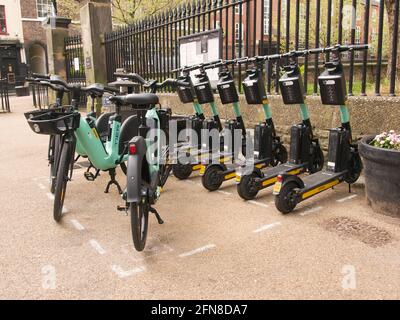 Eine Bucht mit mehrstufigen E-Scootern und E-Bikes neben den ratsbüros im Zentrum von York, North Yorkshire. Stockfoto