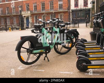 Eine Bucht mit mehrstufigen E-Scootern und E-Bikes neben den ratsbüros im Zentrum von York, North Yorkshire. Stockfoto