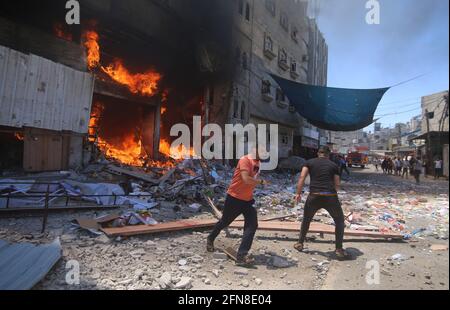 Gaza. Mai 2021. Am 15. Mai 2021, nach einem israelischen Luftangriff auf ein Haus in der Stadt Rafah im südlichen Gazastreifen, laufen Palästinenser davon, als Feuer ausbrach. Quelle: Khaled Omar/Xinhua/Alamy Live News Stockfoto