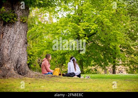 Braunschweig, Deutschland. Mai 2021. Zwei Freunde sitzen auf einer Wiese im Museumspark. Quelle: Moritz Frankenberg/dpa/Alamy Live News Stockfoto