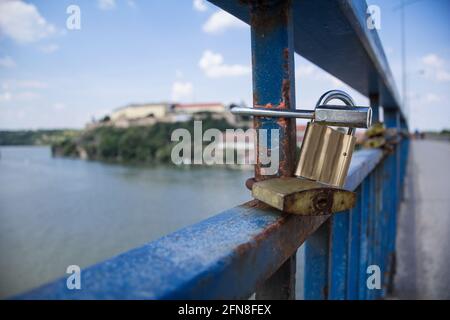 Bild von Liebesschlössern, die an das Geländer einer Brücke in Novi Sad, Serbien, gebunden sind. Ein Liebesschloss oder ein Liebesvorhängeschloss ist ein Vorhängeschloss, das Liebste an eine Brücke schließen, Stockfoto