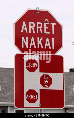 Rot-weißes Stoppschild mit Stopptext in französischer und einheimischer kanadischer Innu-Sprache (arrêt = STOP, nakai = STOP) Stockfoto